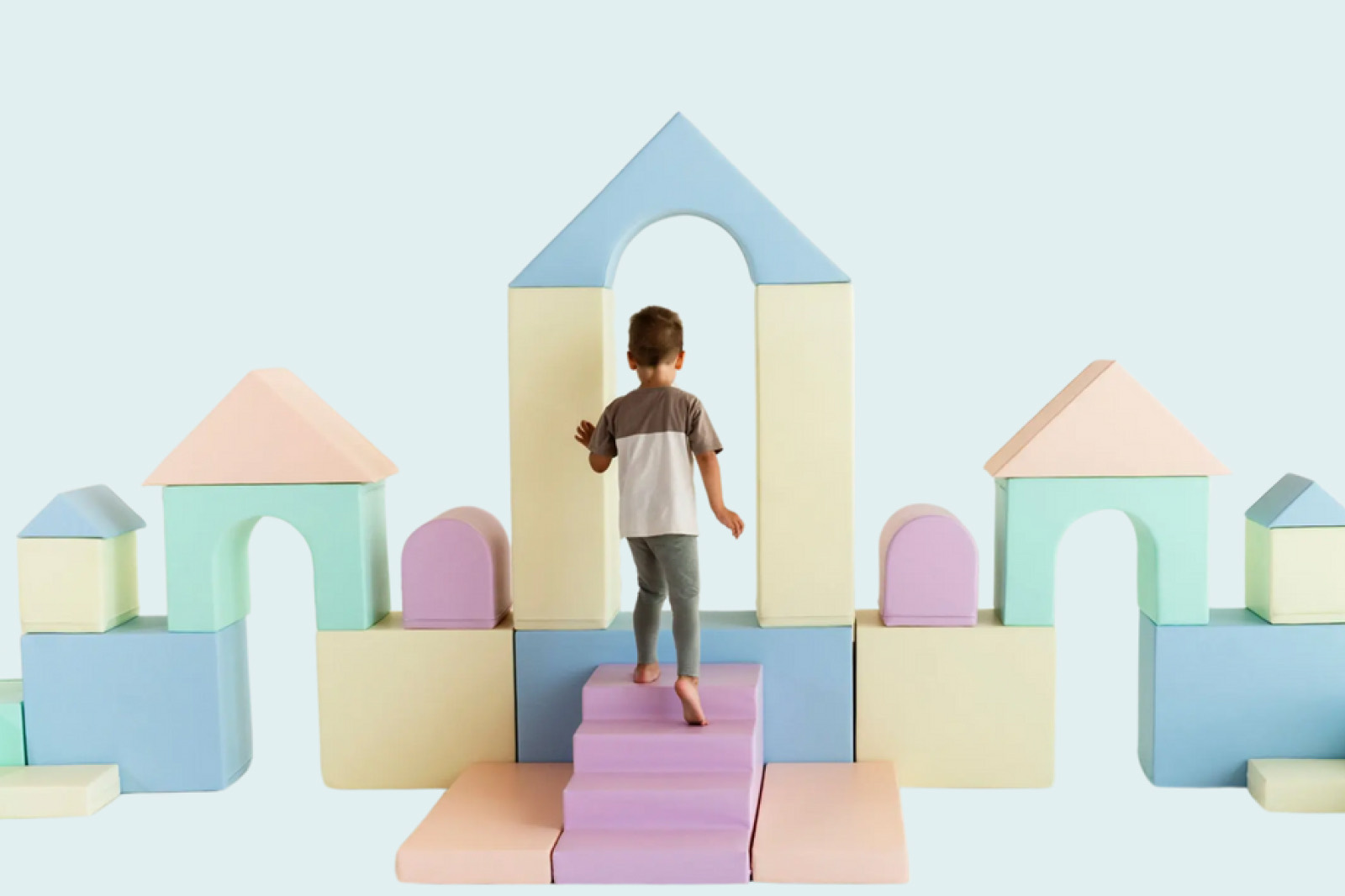 Child playing on a pastel foam soft-play castle